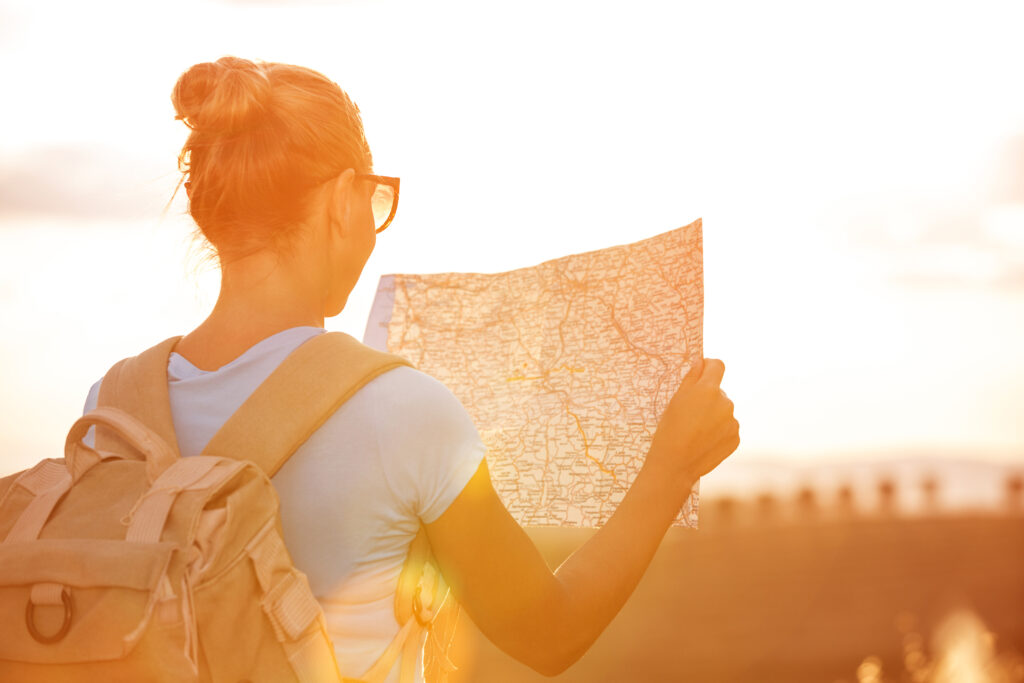 Back,Side,Of,Traveler,Girl,Searching,Right,Direction,On,Map,