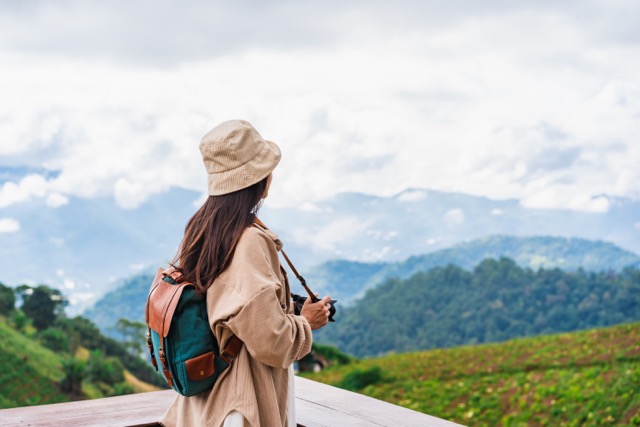 Young woman traveler taking a beautiful landscape at the mountains, Travel lifestyle concept